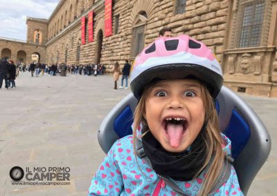 bambina in bici fuori da Palazzo Pitti