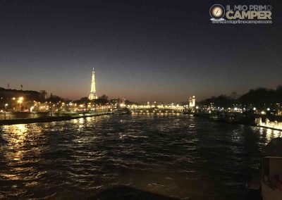 Tour Eiffel di sera illuminata vista dalla Senna